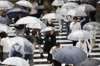 　雨の中、傘を差して歩く人たち