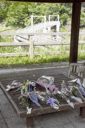 　北海道留萌市の女子高生の殺害現場となった、旭川市の神居古潭地区にあるつり橋付近に手向けられた花束＝２０２４年