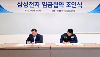　２０２６年の賃金協約の調印式で署名する韓国の電機大手サムスン電子の労使＝２７日、韓国京畿道（サムスン電子提供、聯合＝共同）