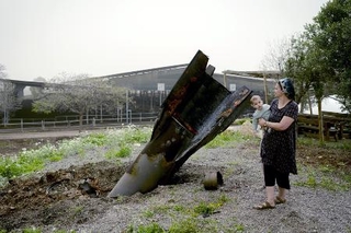 　ヨルダン川西岸のユダヤ人入植地で、イランから発射され着弾した弾道ミサイルを見るイスラエル人女性＝４月（ゲッティ＝共同）