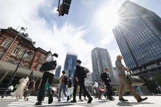 　強い日差しの中、ＪＲ東京駅前を歩く人たち