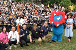 　「ちはや園地」で開催された大阪・関西万博の振り返りイベントで、公式キャラクター「ミャクミャク」と写真に納まる参加者ら＝３１日午前、大阪府千早赤阪村