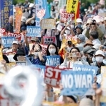 　日本国憲法施行から７９年の憲法記念日を迎え、集会で改憲反対などを訴えたボードを掲げる参加者ら＝３日午後、東京都江東区