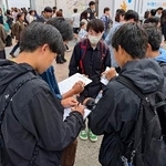 　市民団体「日本平和委員会」が実施した、憲法に関するアンケートに答える若者たち＝３日午後、東京・渋谷