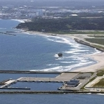 　福島県浪江町の請戸漁港（手前）と東京電力福島第１原発＝２０２３年（共同通信社ヘリから）