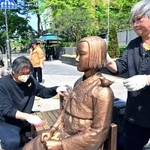 　６日、韓国・ソウルで慰安婦問題を象徴する少女像の保守作業に当たる彫刻家の金曙ギョンさん（右）ら（共同）