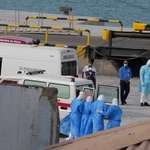 　カボベルデの首都プライアの港で６日、クルーズ船から患者を退避させる防護服姿の医療従事者ら（ＡＰ＝共同）