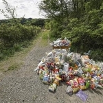 　遺体が遺棄された現場付近に供えられた花や飲み物など＝４月２２日、京都府南丹市