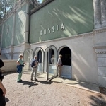 　ロシア館に入れず、屋外から映像を見る来場者＝９日、イタリア・ベネチア（共同）
