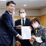 　被爆体験者の岩永千代子さん（右）らから早期救済に向けた要望書を受け取る長崎県の平田研知事＝１１日午後、長崎県庁