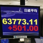 　上げ幅が一時５００円超となり、取引時間中の史上最高値を更新した日経平均株価を示すモニター＝１４日午前、東京都港区の外為どっとコム