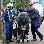 　１６歳以上の自転車の交通違反に反則金納付を通告できる交通反則切符（青切符）制度が始まり、東京都北区の交差点付近で利用者に指導する警察官＝４月１日
