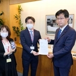 　厚労省の仁木博文副大臣（右）に要望書を提出する「全国コロナ後遺症患者と家族の会」の担当者＝１４日午後、厚労省