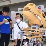 　巡回型展示会「ＫＯＳＥＮ　ＰＡＲＫ」で、小山高専の名物ロボットを操作体験する来場者（左）＝１７日午後、宇都宮市