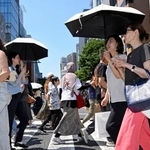 　日傘を差して東京・銀座を歩く人たち。都心は今年初の真夏日となった＝１７日午後