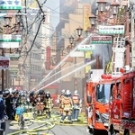 　大阪市中央区の火災現場で、消火活動する消防隊員ら＝１８日午前８時３５分