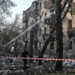 　ウクライナ・ドニプロで、ロシアのミサイル攻撃により損壊した建物付近で活動する消防士＝１８日（ロイター＝共同）