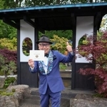 　自身がデザインした庭園を背景にポーズをとる石原和幸さん＝１９日、ロンドン（共同）