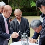 　「平和の塔」から移された原爆の残り火を手にする佐々木雅弘さん（左）＝２０日午前、福岡県八女市