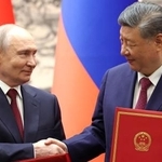 　調印式で握手するロシアのプーチン大統領（左）と中国の習近平国家主席＝２０日、北京の人民大会堂（共同）