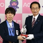 　埼玉県上尾市の畠山稔市長（右）から市栄誉賞のトロフィーを受け取るフィギュアスケートの佐藤駿選手＝２２日午前、上尾市役所