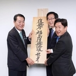 　「福島復興浜通りセンター」の開所式で看板を掛ける牧野復興相（左）＝２４日午後、福島県双葉町