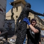 　ロシア軍の攻撃で損壊したチョルノービリ原発事故の博物館から展示品を運ぶ男性＝２４日、ウクライナ・キーウ（ロイター＝共同）