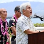 　２４日、米ハワイの真珠湾で開かれた式典であいさつする佐々木住幸さん。左端は雅弘さん（共同）