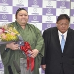 　引退記者会見を終え花束を手にする元幕内剣翔。右は追手風親方＝４月、東京・両国国技館