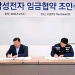 　２０２６年の賃金協約の調印式で署名する韓国の電機大手サムスン電子の労使＝２７日、韓国京畿道（サムスン電子提供、聯合＝共同）