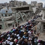 　イスラエルの攻撃で破壊されたモスクのそばで祈りをささげる人々＝２７日、パレスチナ自治区ガザ南部ハンユニス（ＡＰ＝共同）