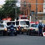 　マイクロバスに歩行者がはねられた交差点を交通規制する警察官＝２９日午後７時７分、名古屋市南区