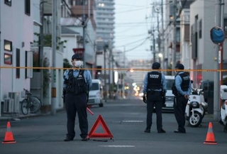 　男女２人が死亡する事件があった現場付近で警戒する警察官＝１日午後７時３分、埼玉県川口市
