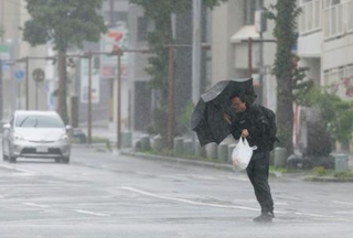 　台風６号の影響で風雨が強まる鹿児島市内を歩く男性。３日にかけて西日本から東日本の太平洋側に近づく恐れがある＝２日午前