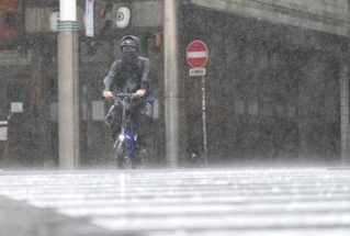 　台風６号の影響で雨が強まる中、自転車で走る男性＝２日午後、宮崎市