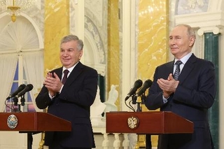 　ウズベキスタン初の原発建設開始の式典にオンラインで参加するミルジヨエフ大統領（左）とロシアのプーチン大統領＝４日、ロシア・サンクトペテルブルク（タス＝共同）