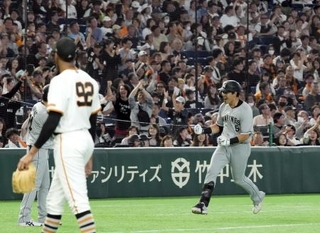 　９回、同点ソロを放ち本塁に向かうロッテ・安田。左はマルティネス＝東京ドーム