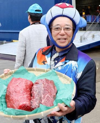 　ナガスクジラの肉を手にする共同船舶の所英樹社長＝８日午前、仙台市