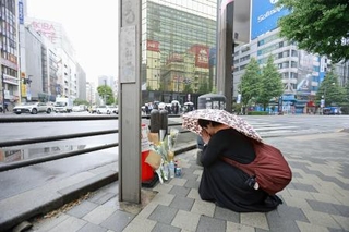 　東京・秋葉原の無差別殺傷事件現場となった交差点で手を合わせる人＝８日午前