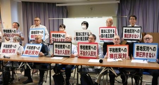 　記者会見でプラカードを掲げる被爆者団体などの代表者ら＝８日午後、長崎市