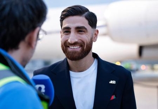 　メキシコ・ティフアナの空港に着いて記者の質問に答えるイラン代表のＭＦジャハンバフシュ＝７日（ゲッティ＝共同）