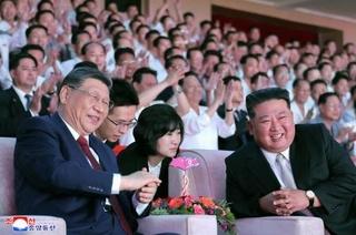 　眼鏡をかけて芸術公演を鑑賞する中国の習近平国家主席。右は北朝鮮の金正恩朝鮮労働党総書記＝８日、平壌（朝鮮中央通信＝共同）
