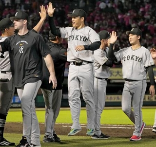 　プロ野球２４人目となる全球団勝利を達成し、跳び上がってナインとタッチを交わす巨人・則本（中央）＝楽天モバイルパーク