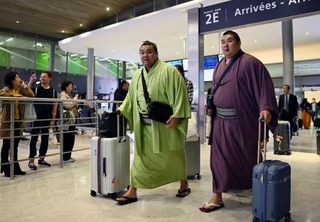 　大相撲パリ公演に向け、フランスのシャルル・ドゴール空港に到着した大関霧島（左）ら＝９日、パリ近郊（共同）