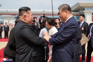 　帰国前に北朝鮮の金正恩朝鮮労働党総書記（左）と握手する中国の習近平国家主席＝９日、平壌（朝鮮中央通信＝共同）