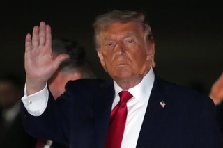 　米東部メリーランド州のアンドルーズ空軍基地で大統領専用機から降りる際に手を上げるトランプ大統領＝９日（ＡＰ＝共同）