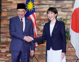 　会談前に握手するマレーシアのアンワル首相（左）と高市首相＝１０日午前、首相官邸