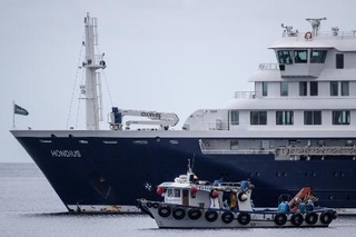 　小型船でクルーズ船から離れる乗客＝５月、スペイン・テネリフェ島（ゲッティ＝共同）