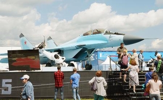 　モスクワ郊外の飛行場で開催中の国際航空見本市「ＭＡＫＳ２０１７」で、ロシアの最新鋭戦闘機ミグ３５を見学する人たち＝２０１７年７月（共同）