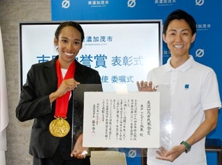 　岐阜県美濃加茂市の藤井浩人市長（右）から市民栄誉賞を贈られた陸上の井戸アビゲイル風果選手＝１５日午前、美濃加茂市役所